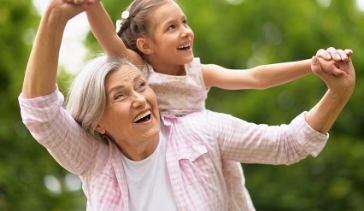 Elderly woman carrying young girl